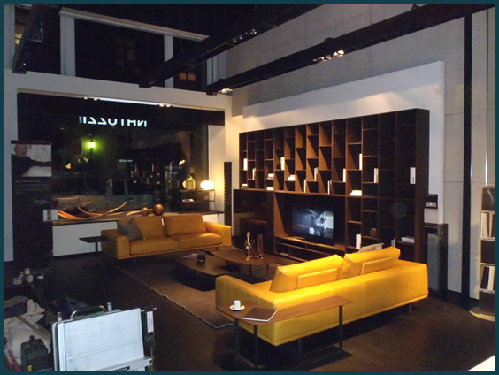 Lighted ceiling beams with lighted shelving on floating walls for showroom.